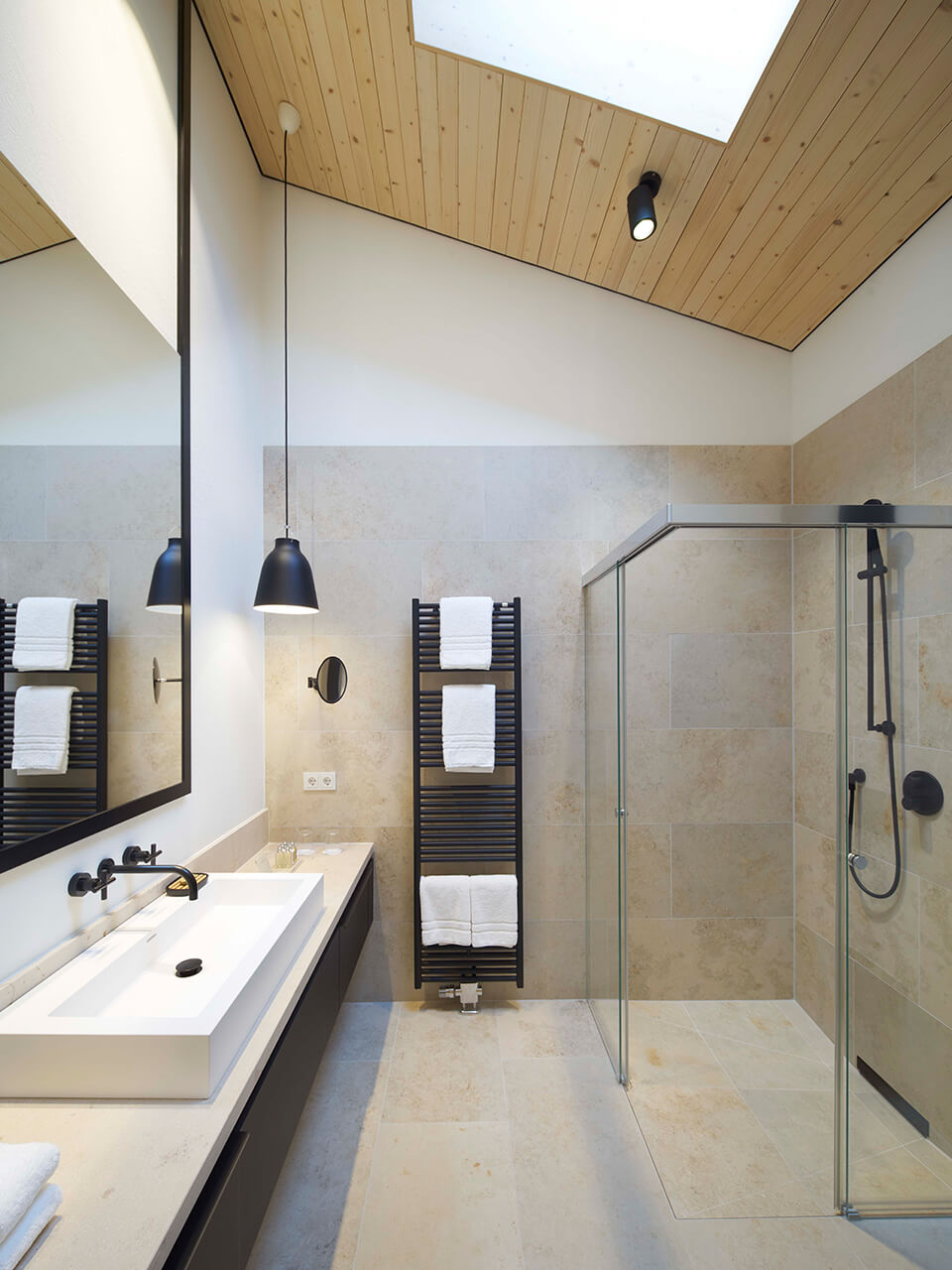 Ein modernes Badezimmer mit großer Dusche und einem Deckenfenster