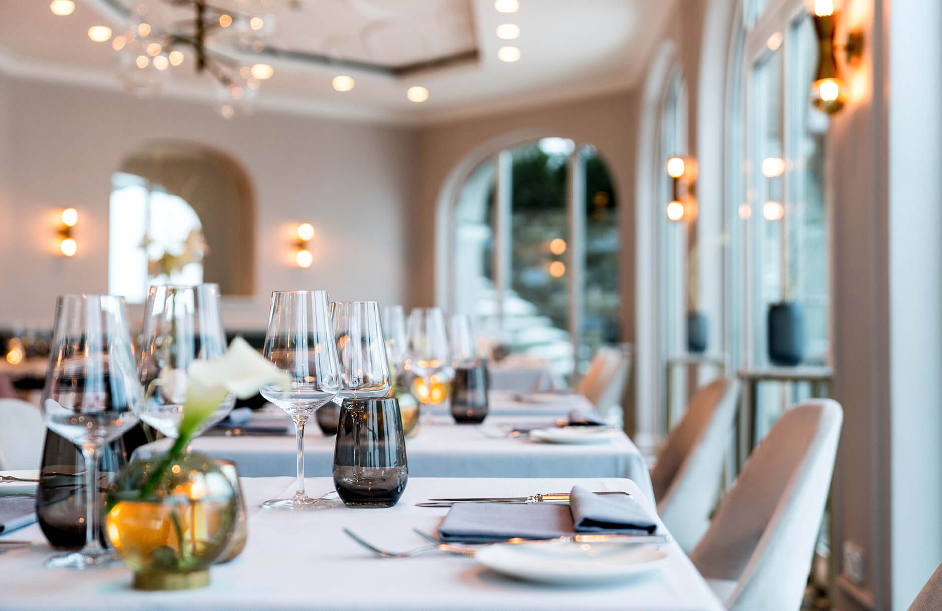 Aufnahme im Restaurant Senger am Tegernsee mit Tischen, die zum Abendessen eingedeckt sind.