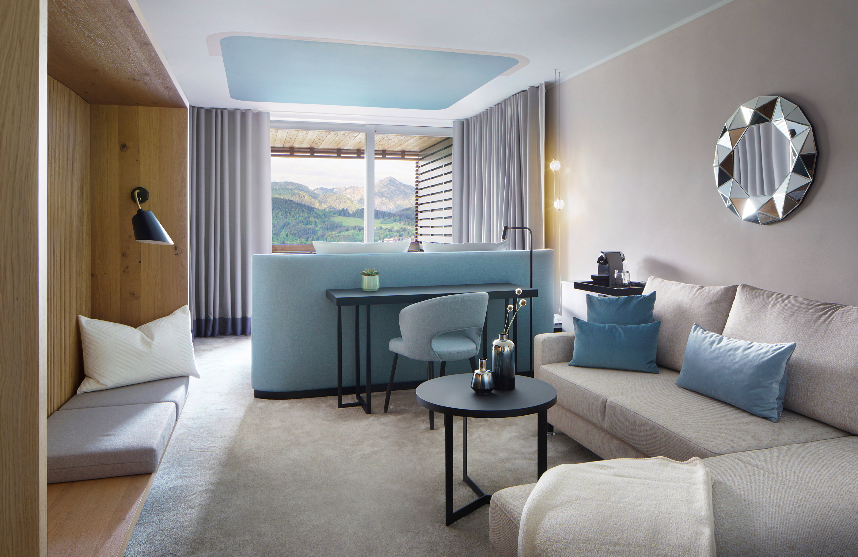 Aufnahme des Wohnbereichs mit hellem grauem Sofa und Teppich sowie blauen Akzenten