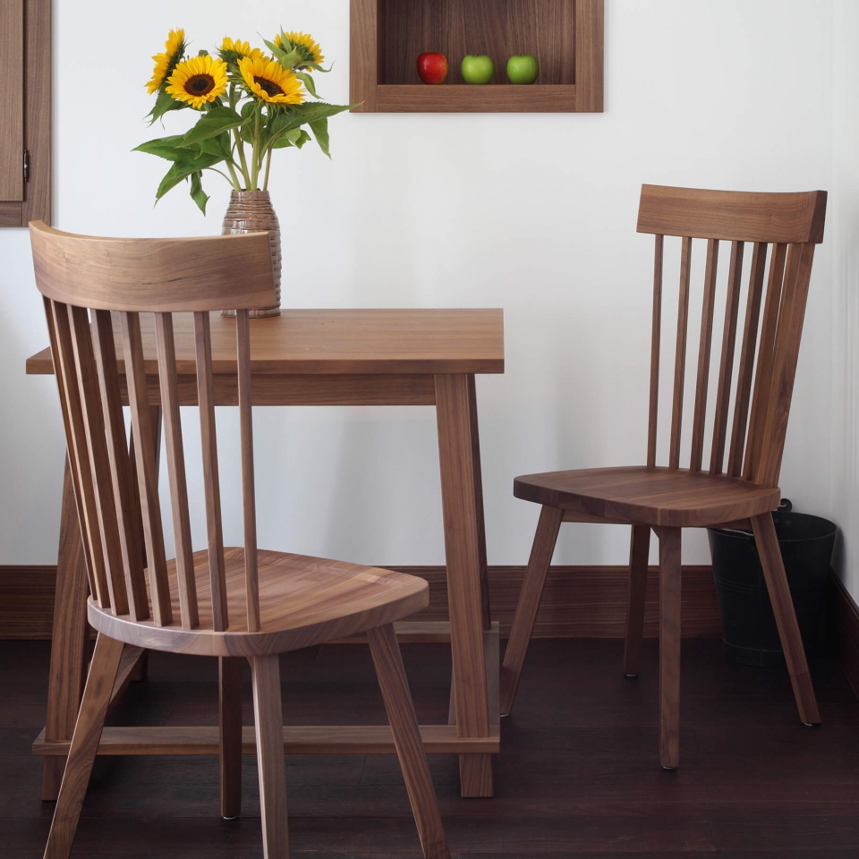 Sonnenblumen stehen auf einem Holztisch mit zwei Stühlen im Hotelzimmer des Luxushotels