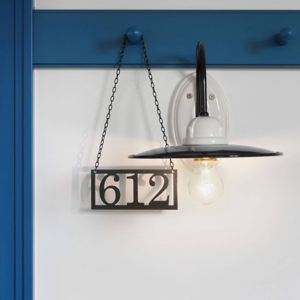 Nahaufnahme einer Zimmernummer, die neben einer Lampe hängt
