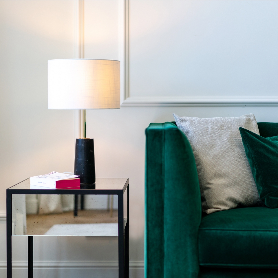 Detailaufnahme eines Samtsofas mit kleinem Beistelltisch