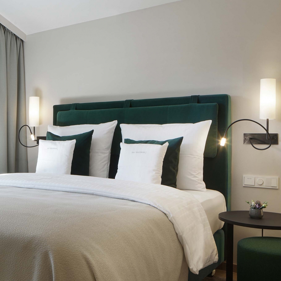 Ein gemütliches Bett mit dunkelgrünen Details