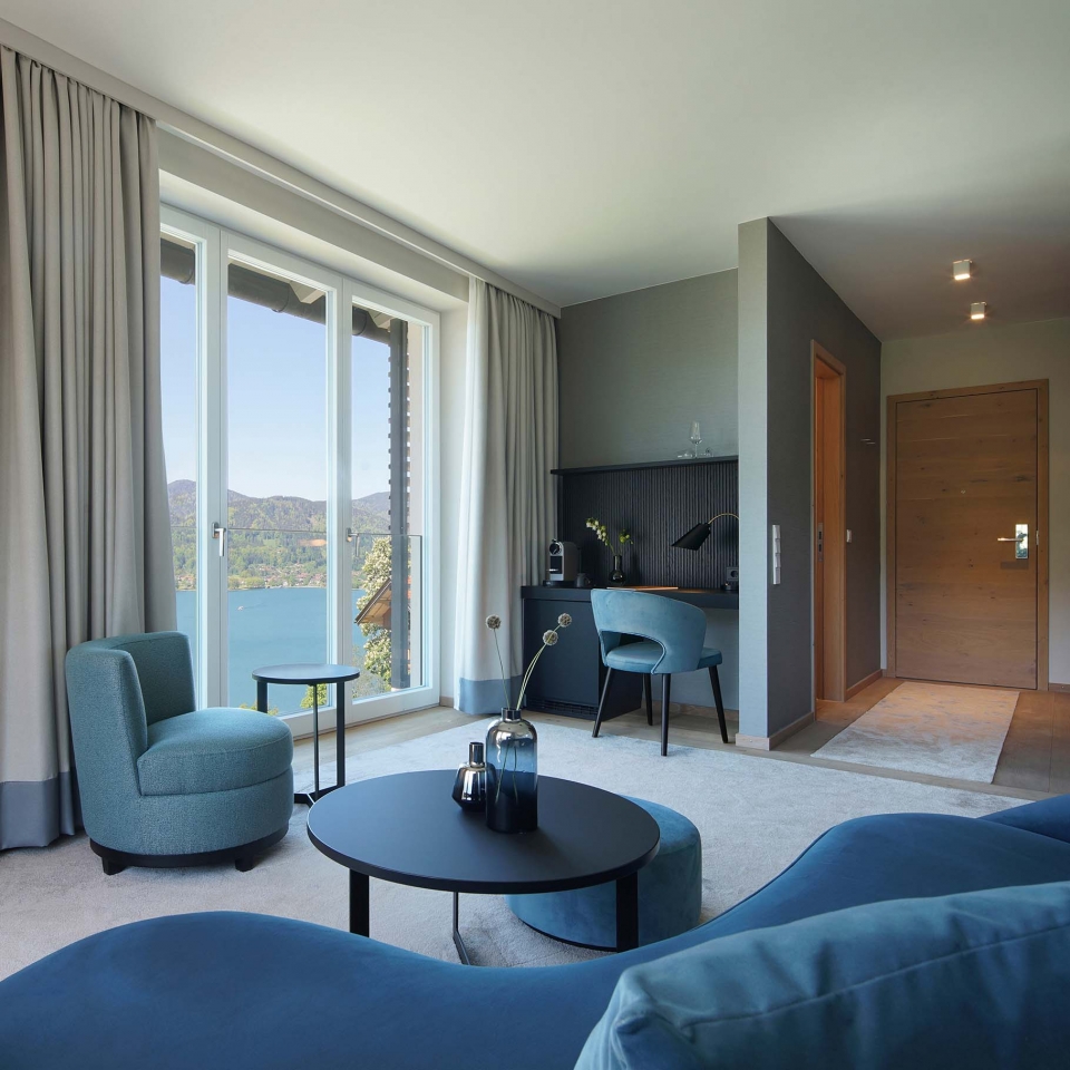 Blick vom Sofa auf die Schreibtischecke mit Kaffeemaschinen und herrlichem Ausblick auf den See